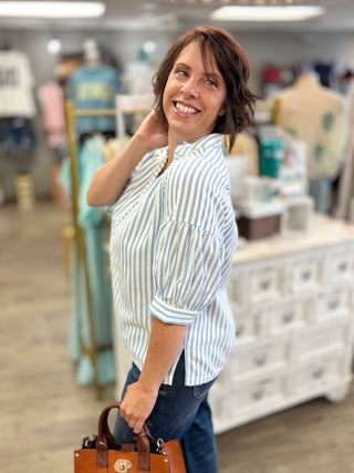 Model wearing blue and white striped top 