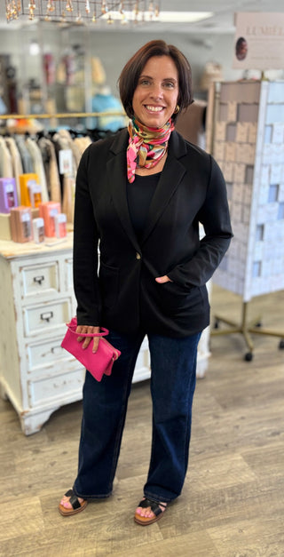 Model wearing black blazer with scarf accessory 
