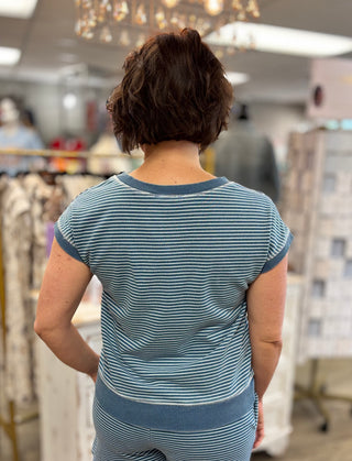 Person wearing a blue striped shirt in a store setting