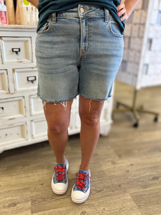 Person wearing denim shorts and sneakers in a casual setting
