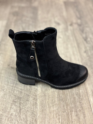 A single black suede ankle boot with a side zipper, shown from a side profile view on a light wood floor.