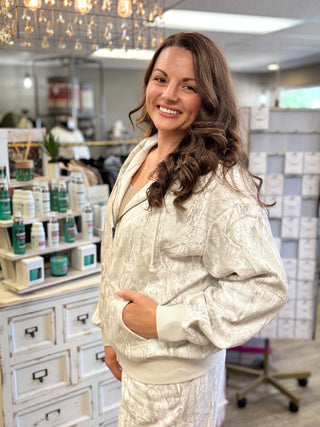Model wearing a white grey camo printed zip up hoodie