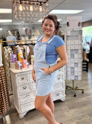 Woman wearing a blue and white striped overalls in a store setting