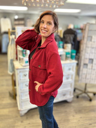 Model wearing a red shacket and denim jeans 