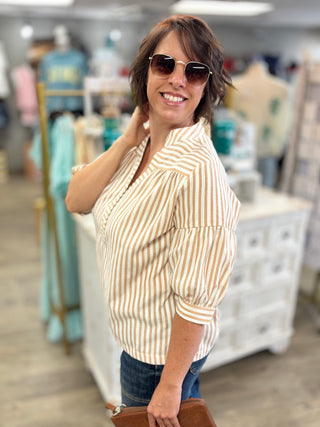 Model wearing tan and white striped top 
