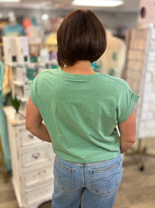 Person wearing a green shirt and blue jeans in a store setting