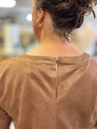 Close-up of the Salted Caramel Suede Top back detail with a covered button keyhole closure, contrast stitching and inverted pleat