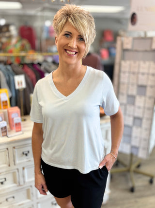 Woman wearing a light blue t-shirt and black shorts in a store setting