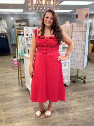 Model wearing red dress with smocked bodice and tie detail
