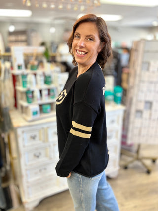 Side view of the black Purdue Boilermakers sweater showing its long sleeves and medium length