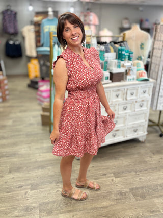 Woman in a pink floral dress standing in a store