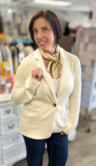 Model wearing ecru blazer with scarf accessory