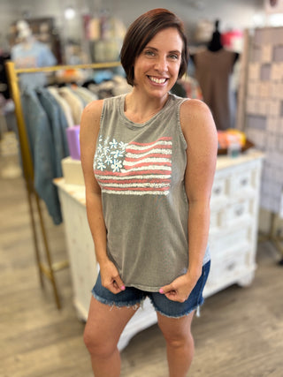 Woman wearing a gray tank top with an American flag design in a store setting
