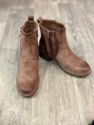 A pair of brown suede ankle boots with double zipper detail