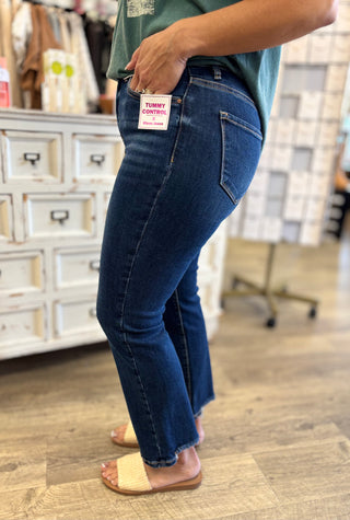 Model wearing dark wash tummy control jeans in a store