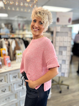 Model wearing pink short sleeve top in a store