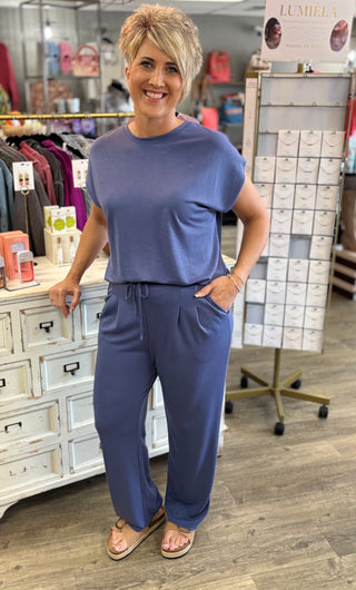 Woman wearing a blue pant set standing in a store setting.