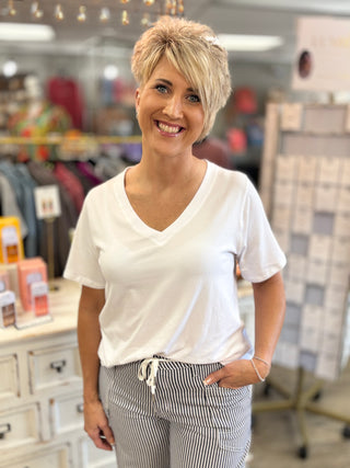 Woman wearing a white t-shirt and striped pants in a store setting