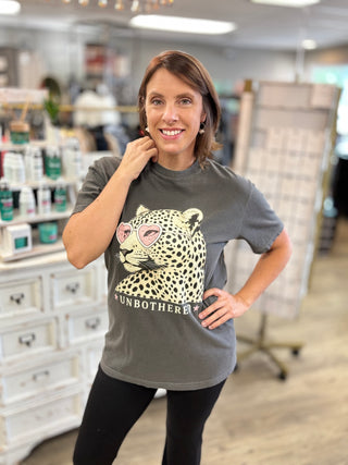 Model wearing a pepper black graphic tee shirt with “unbothered”