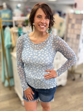 Model wearing blue daisy mesh long sleeve top