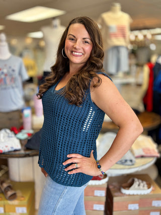 Model wearing a teal sleeveless crochet top and jeans