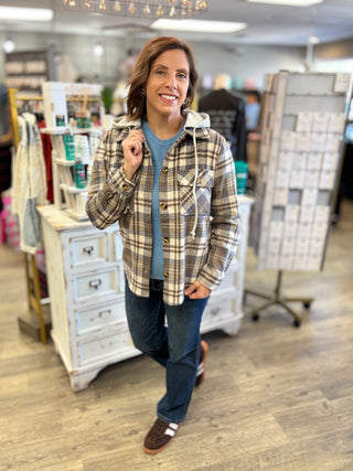 Model wearing brown, cream, and blue plaid shacket with jeans