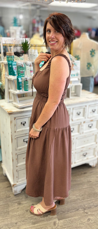 Woman wearing a brown dress standing in a store.