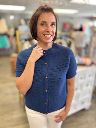Woman wearing a blue knitted cardigan in a store setting
