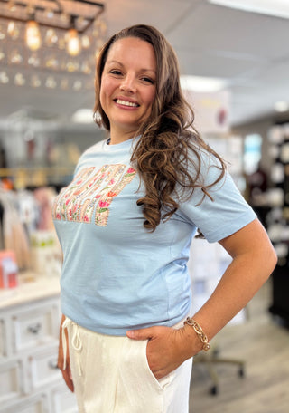 Model wearing light blue shirt that says ‘AMEN’