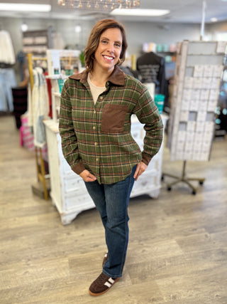 Woman wearing the Cabin Fever olive and chocolate brown plaid flannel shirt with a brown corduroy collar and patch pocket, styled over a cream tee with dark jeans and brown sneakers