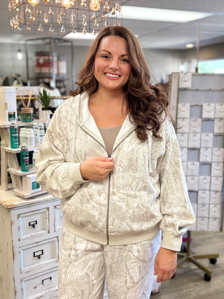 Model wearing a white grey camo printed zip up hoodie