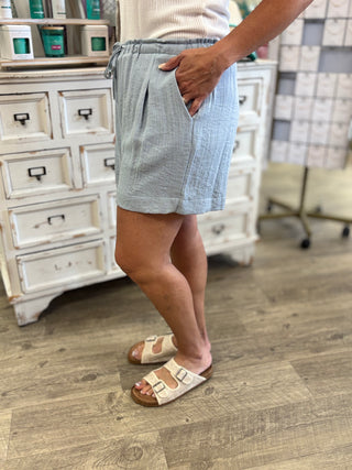 Model wearing light blue shorts with drawstring detail