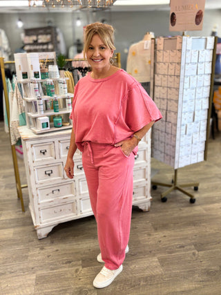 Model wearing a strawberry pink set with reverse stitching details