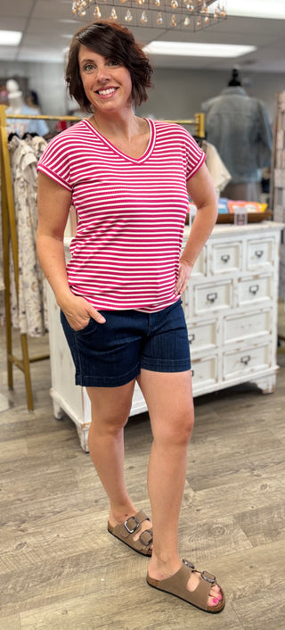 Model wearing fuchsia and white striped top with denim shorts