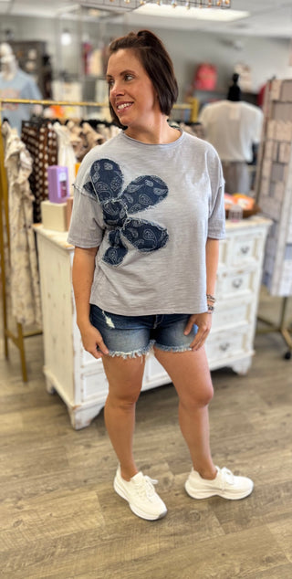Woman wearing a blue t-shirt with a graphic design in a store setting