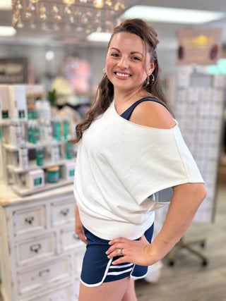 Woman wearing a white top and navy shorts in a store setting