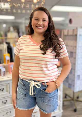Woman wearing a striped shirt and denim shorts in a store setting