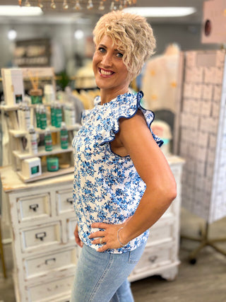 Woman wearing a blue floral top in a store setting