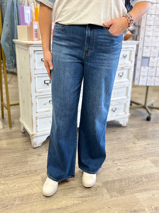 Person wearing blue jeans and a white shirt in a store setting