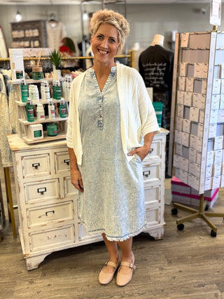 Model wearing a light wash chambray dress with a cardigan
