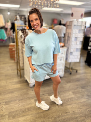 Woman wearing a light blue outfit in a store setting