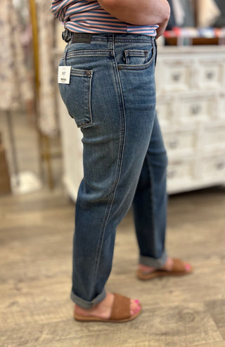 Person wearing blue jeans with a visible brand tag in an indoor setting