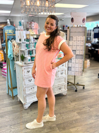 Model wearing coral and white striped dress with pockets