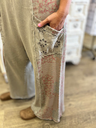 Close up of stone grey and patchwork overalls with pockets