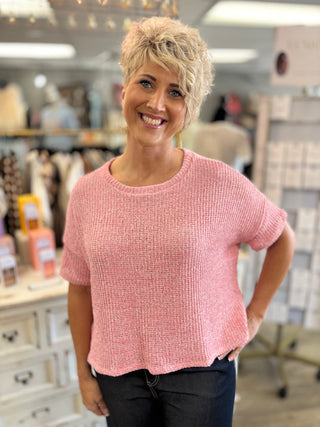 Woman wearing a pink sweater in a store setting