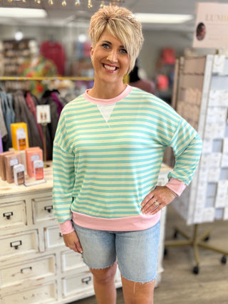 Woman wearing a striped long sleeve shirt and denim shorts in a store setting