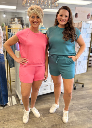 Two women posing together in a store wearing matching outfits.