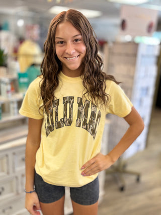 Model wearing butter yellow LULU MAC t-shirt with Mossy Oak camo detail