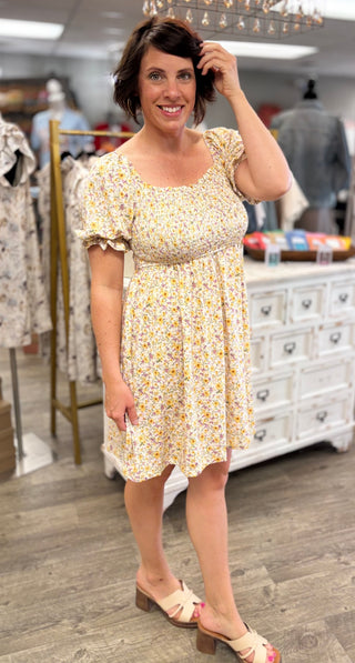 Model wearing yellow and purple floral dress in a store