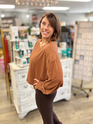 Model wearing a chestnut colored long sleeve top with brown leggings